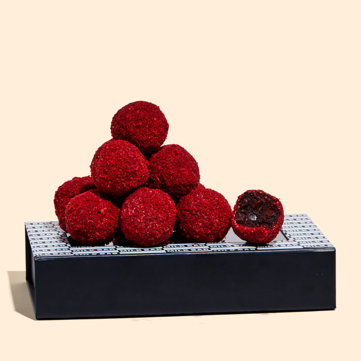 Red Velvet Cheesecake Cake Truffle Pile on top of their branded packaging.