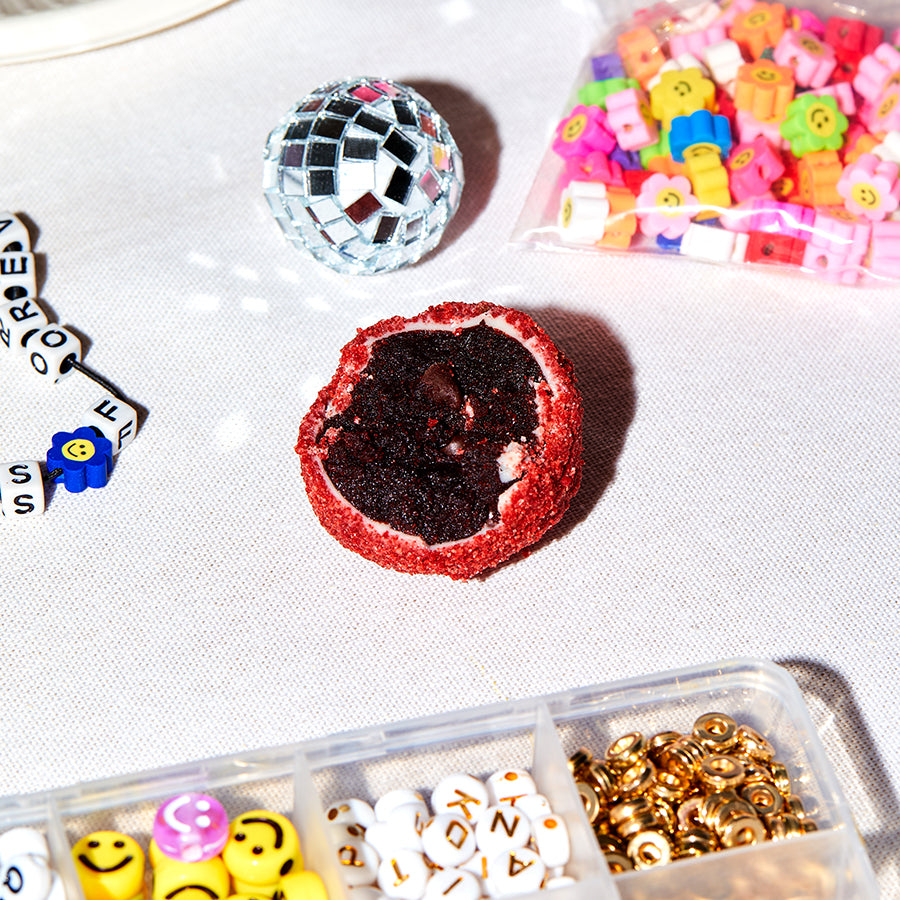 close up of a single red velvet cheesecake truffle on a craft table