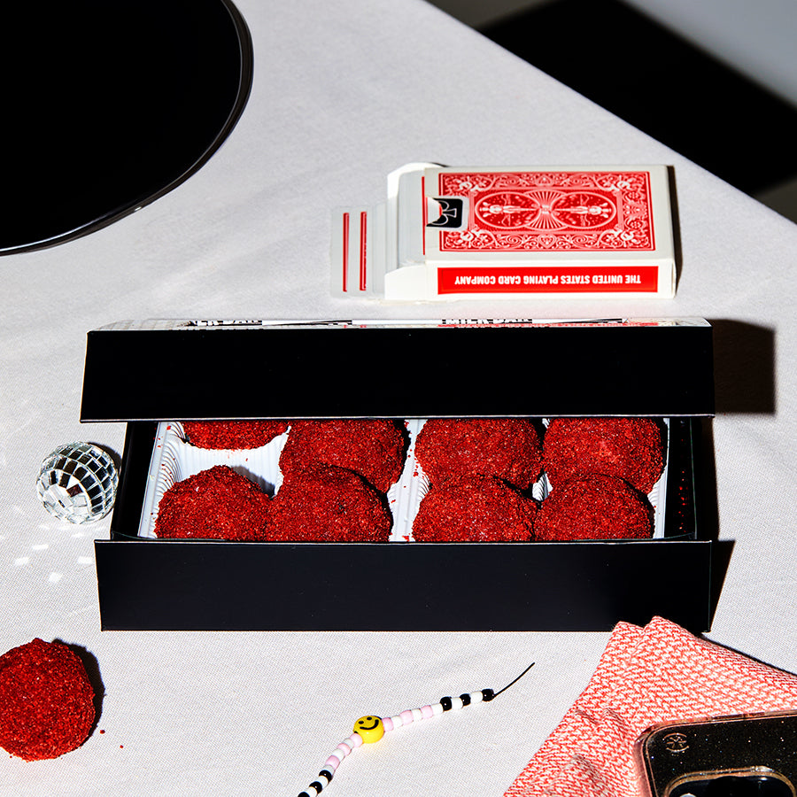 a box of red velvet cheesecake truffles on a festive table with the lid slightly ajar