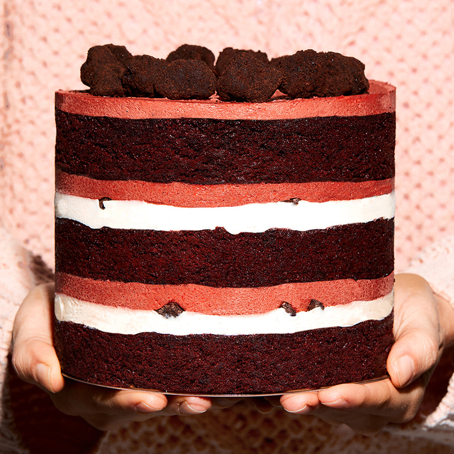 Close up side view of a 6" Red Velvet Cake Side being presented in a person's hands | Upgrade Image